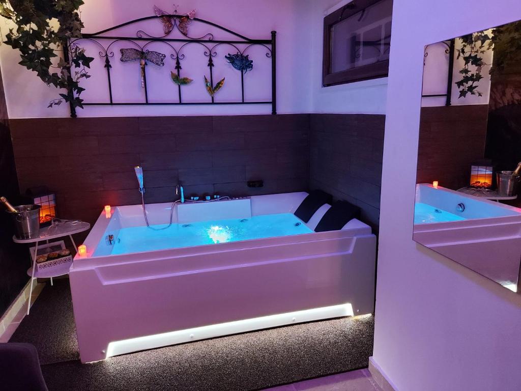 塔兰托B&B Taras Di San Vito的紫色照明的客房内的浴缸