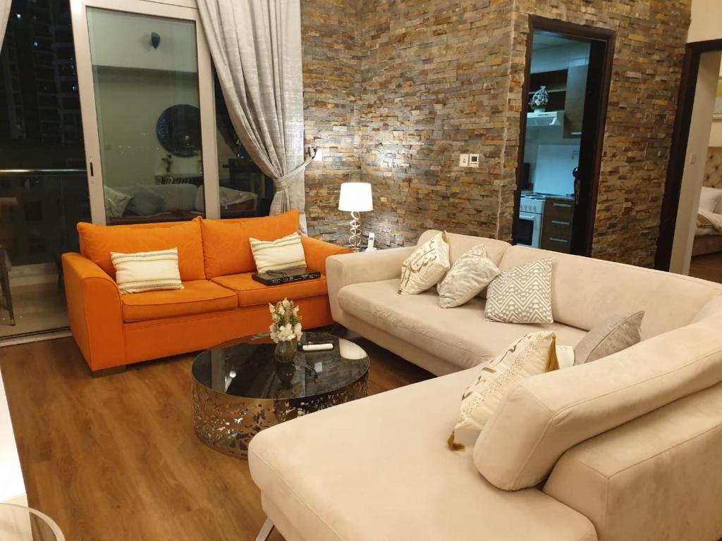 迪拜Luxury 1br in Dubai Marina, ask for July Full month offer的客厅配有两张沙发和一张桌子