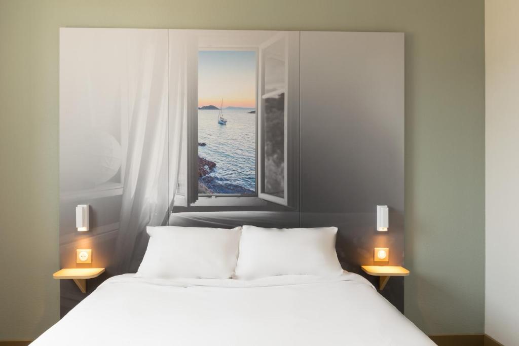 Saint-VictoretB&B HOTEL Marseille Aéroport Saint-Victoret的卧室配有白色的床和窗户