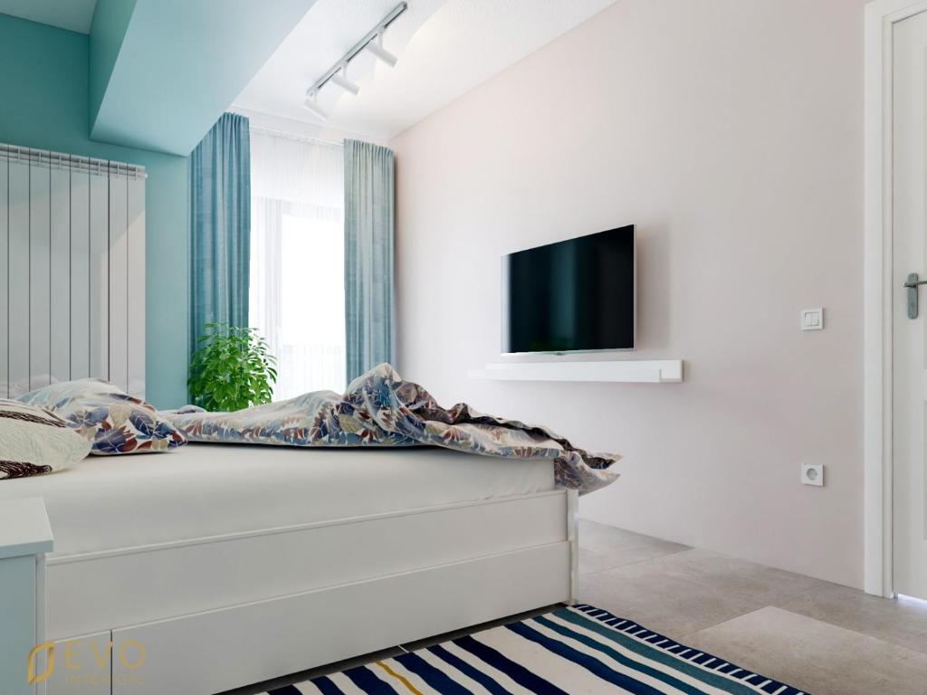 马马亚Mamaia Beach LuxyMar 1 Apartment的一间卧室配有一张床,墙上配有电视