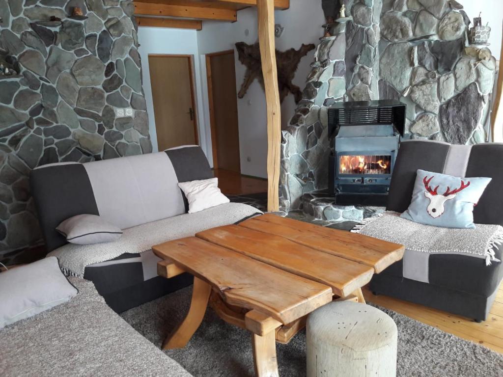 库普雷斯Chalet Katy的客厅设有石制壁炉和木桌。
