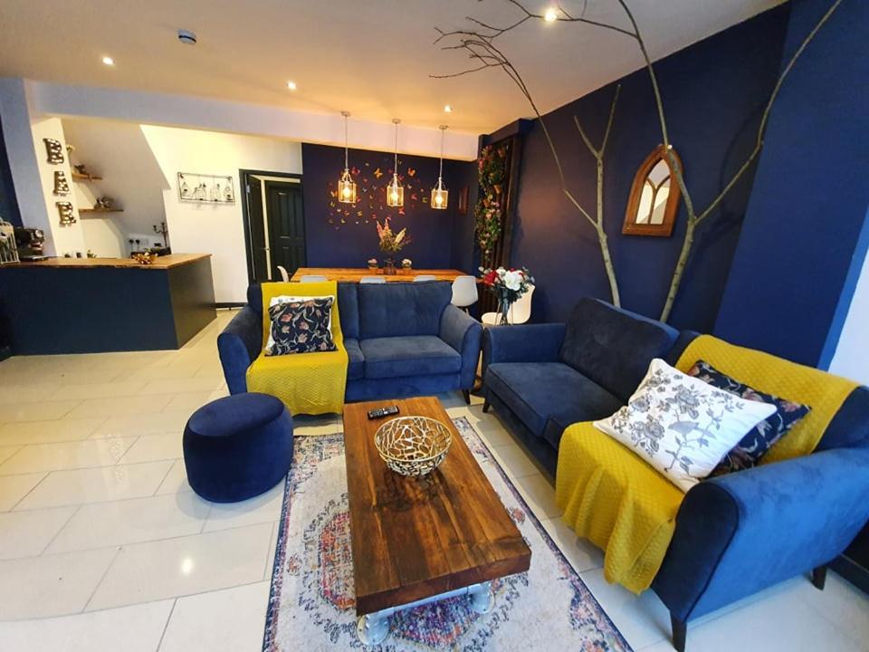 巴斯Enchanted Hideaway, Bath的客厅配有蓝色的沙发和桌子