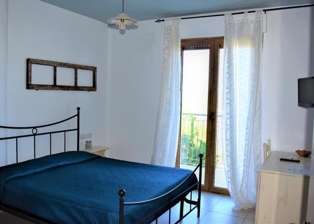 阿夸维瓦皮切纳Casolare Azzurro的一间卧室设有一张床和一个大窗户