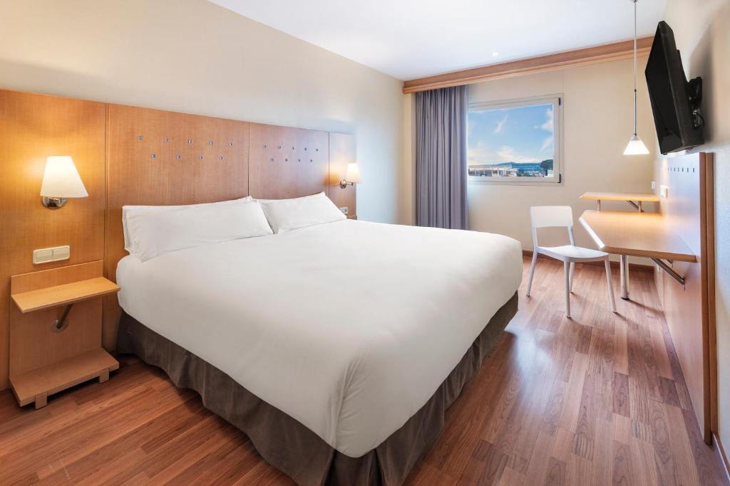 阿尔甘达·德尔·雷伊B&B HOTEL Madrid Arganda的酒店客房设有一张大床和一张书桌。