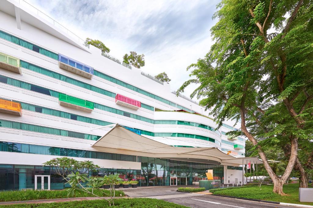 新加坡Village Hotel Changi by Far East Hospitality的一座白色的大建筑,前面有帐篷