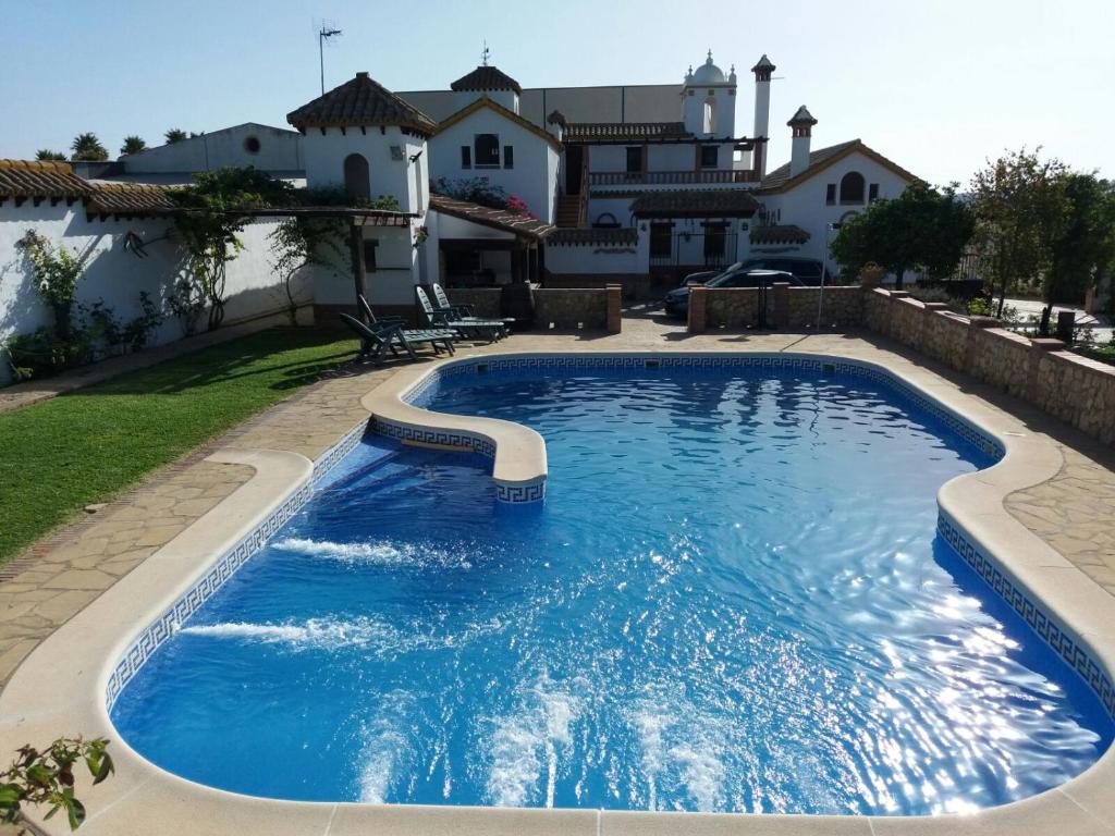 阿尔科斯-德拉弗龙特拉La Cazuela的一座带房子的庭院内的游泳池