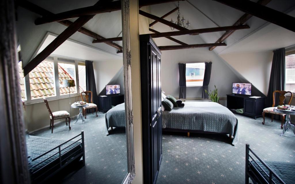 斯滕韦克Stadslogement De Oude Smidse Steenwijk的一间卧室设有一张床和一间客厅。