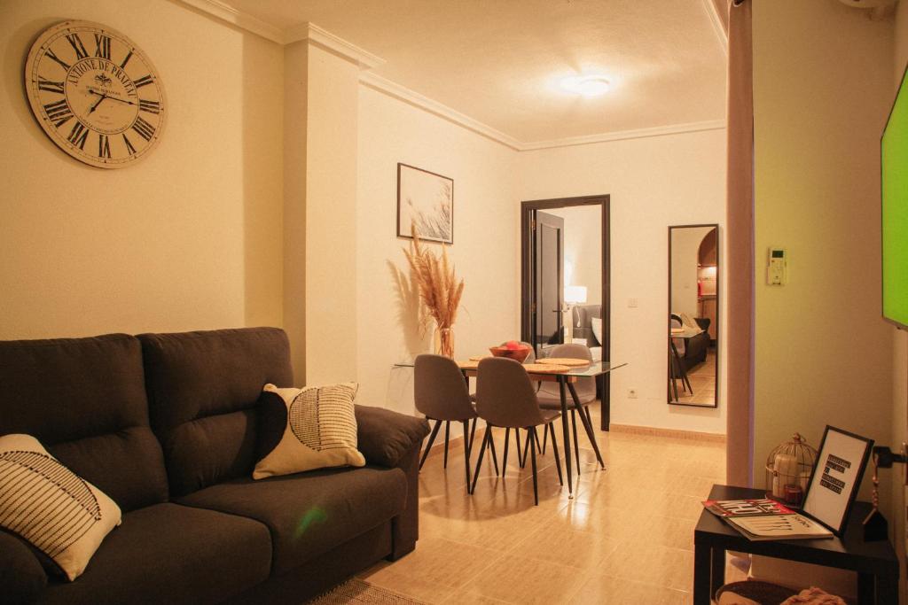 托雷维耶哈Aparthotel Costa Blanca的客厅配有沙发和墙上的时钟