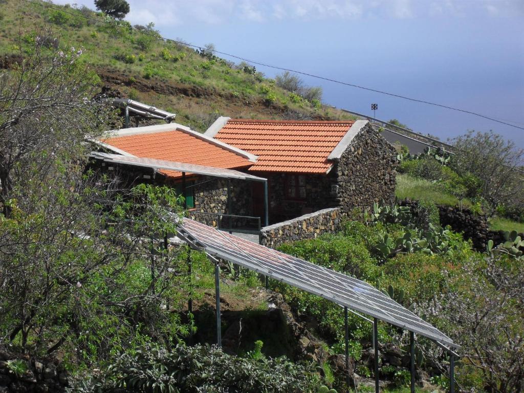 拉斯卡萨斯Casa Rural Abuelo Pancho的山边的房屋,设有太阳能电池板