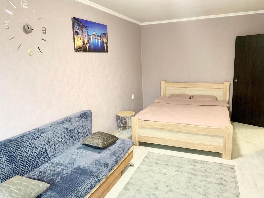 切尔尼戈夫Апартаменты в центре по проспекту Победы парковка рядом的一间卧室配有一张床和一张沙发