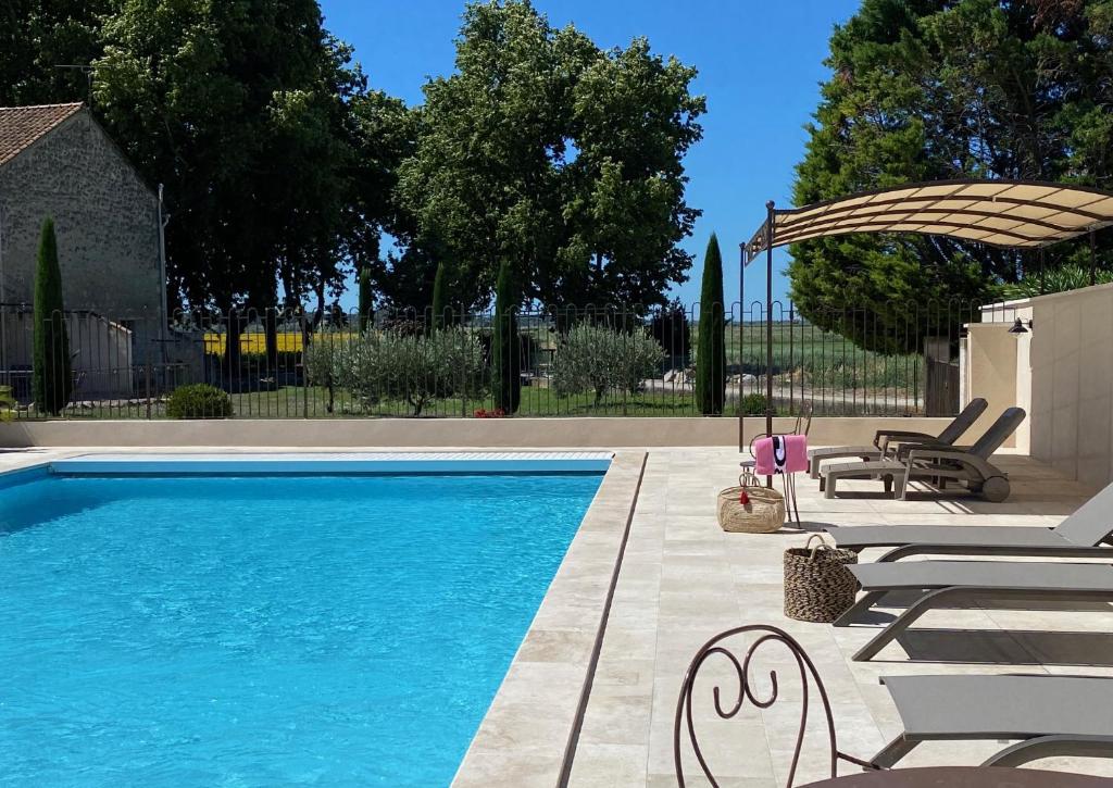 丰维耶Le Domaine de Laforest的一个带2把躺椅和遮阳伞的游泳池