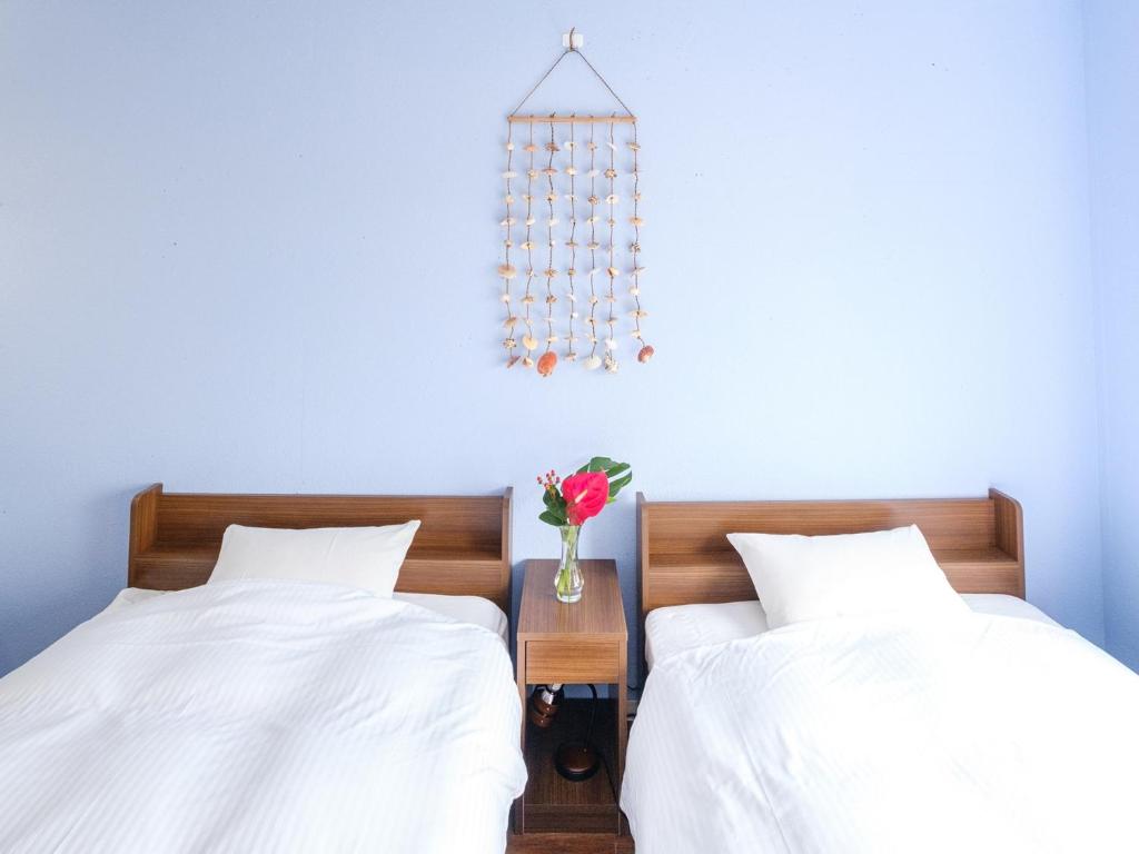 宫古岛Hotel Shion no Umi - Vacation STAY 98886的两张带白色床单和花瓶的床