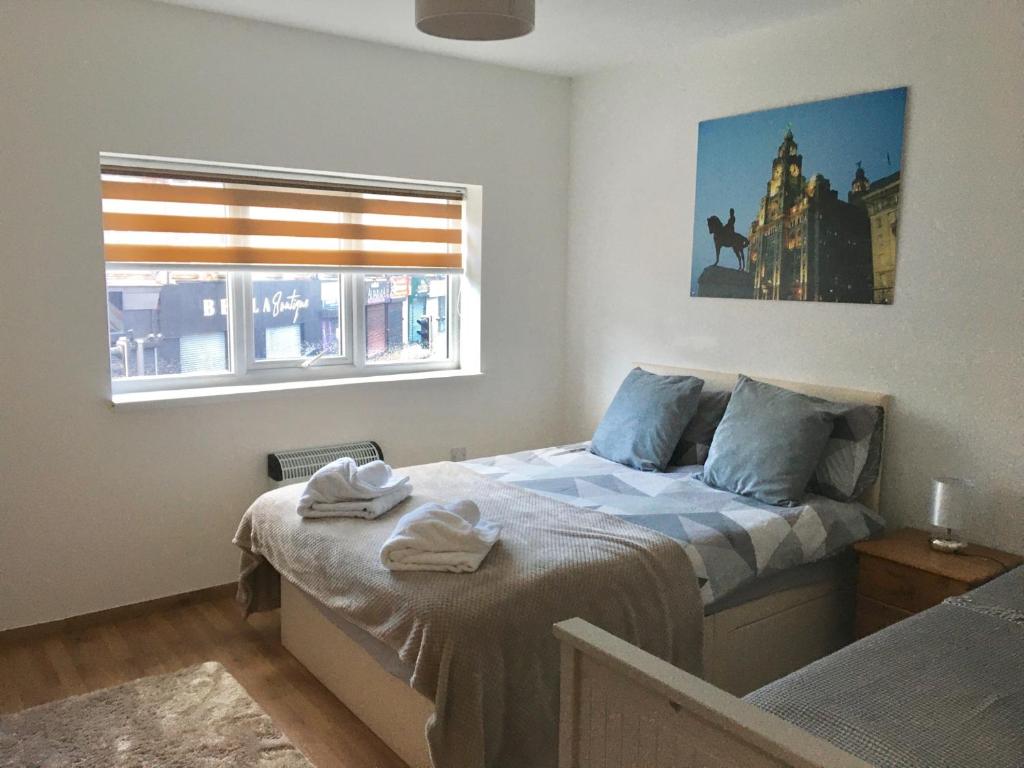 利物浦Flats near football clubs的一间卧室设有一张床和一个窗口