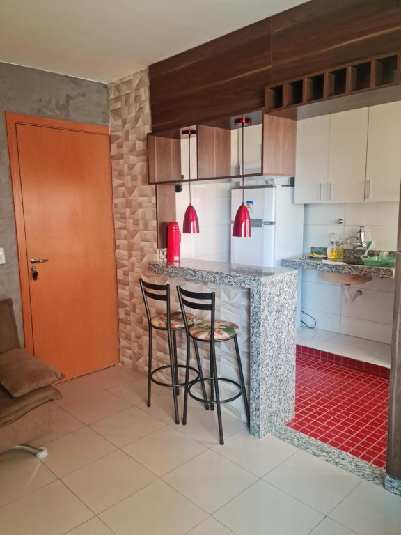 戈亚尼亚Morro Vermelho的厨房配有2张吧台凳和1个柜台。