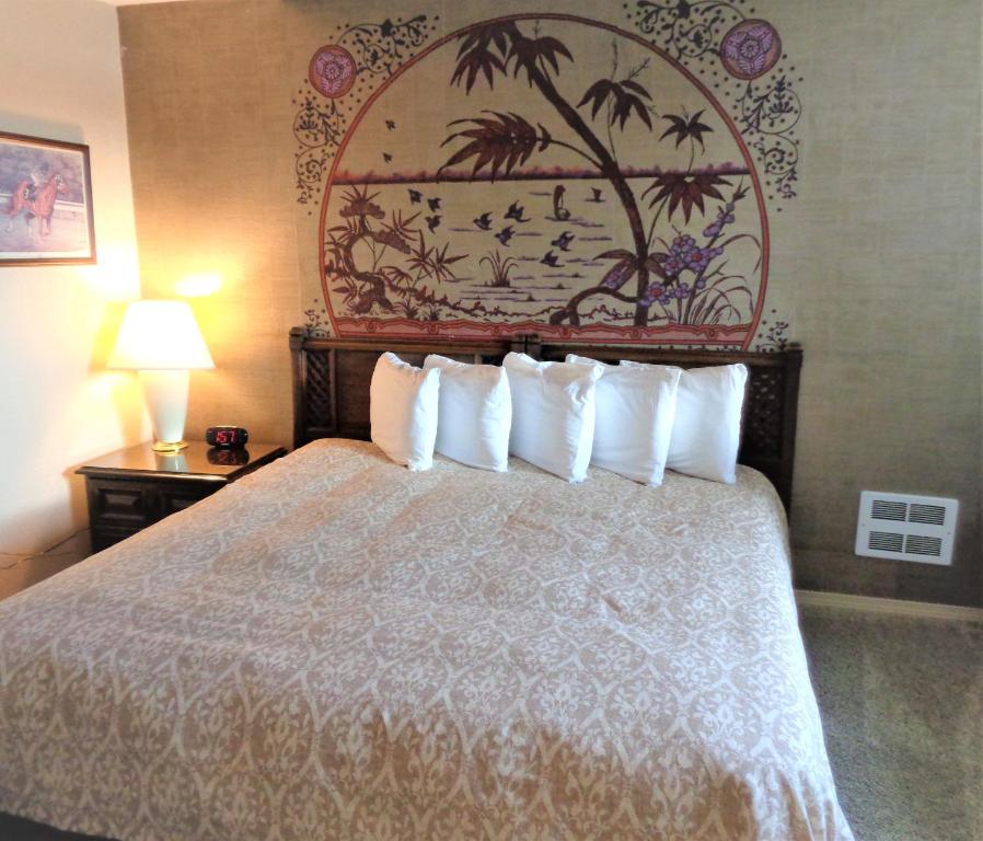 洋滨市波利尼西亚度假村的配有白色枕头的床的酒店客房