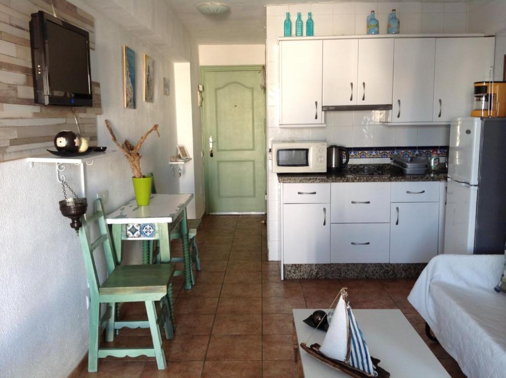 贝纳尔马德纳The Studio的厨房配有白色橱柜和桌椅
