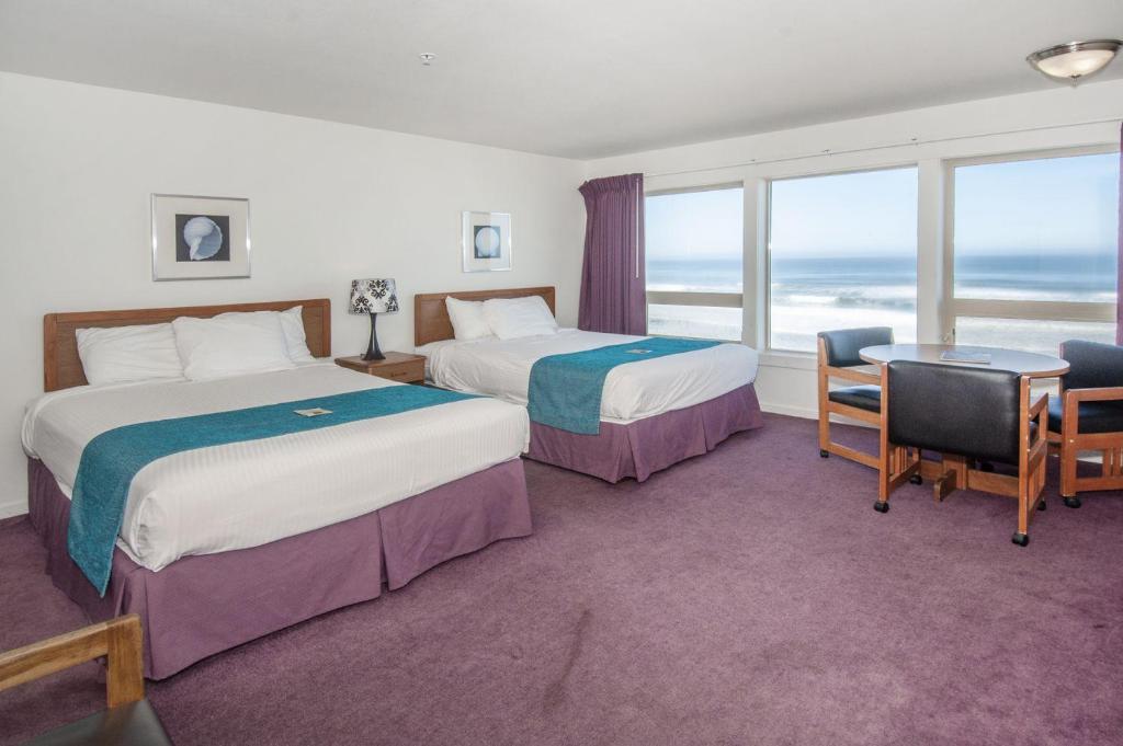 林肯市Seahorse Oceanfront Lodging的酒店客房设有两张床,享有海景。
