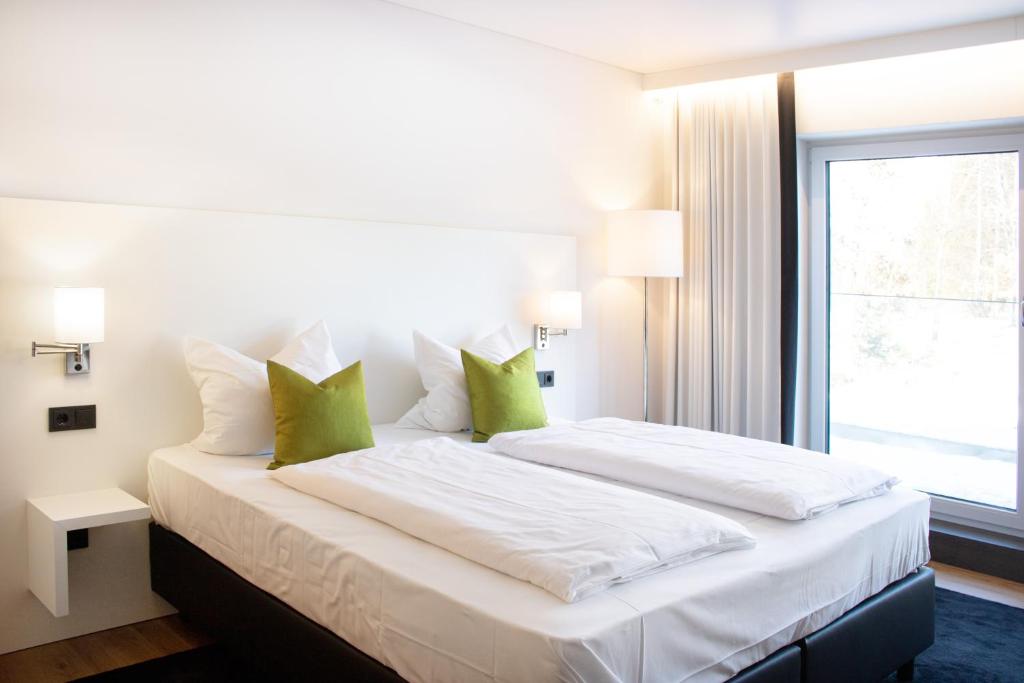 考夫博伊伦KF Hotel by WMM Hotels的卧室配有带绿色枕头的大型白色床