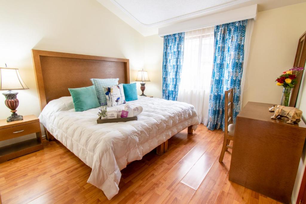 瓜达拉哈拉Casa Kinich的一间卧室配有一张带蓝色窗帘的大床