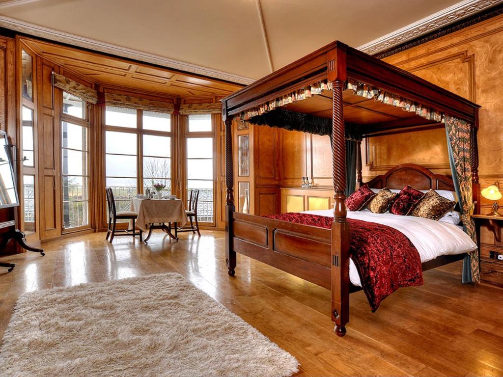 格兰奇奥沃桑茨海湾别墅住宿加早餐旅馆的一间带天蓬床的卧室和一间用餐室