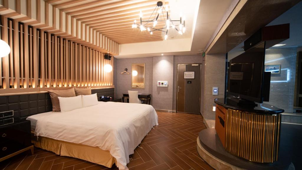 永和爱摩儿时尚旅舘的一间卧室配有一张床和一台平面电视