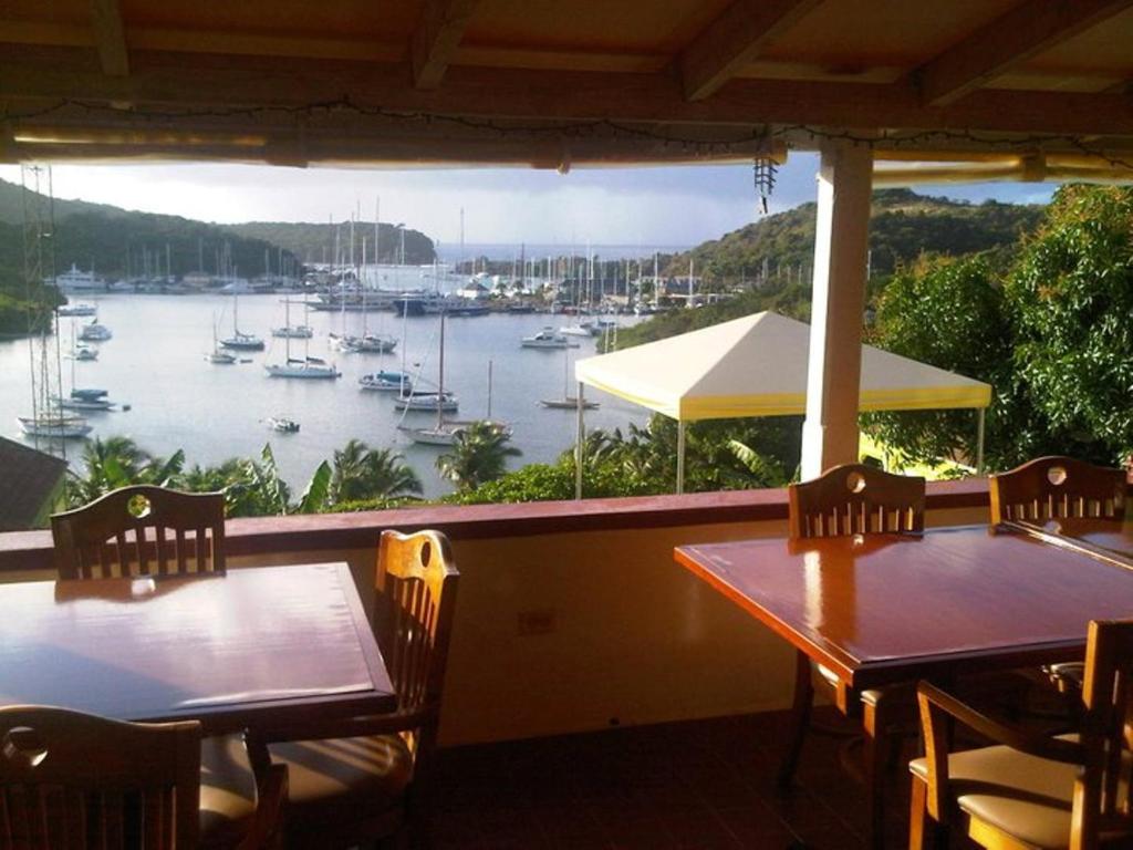 英吉利港安提瓜海洋酒店的门廊上设有两张桌子和椅子,享有海港景色