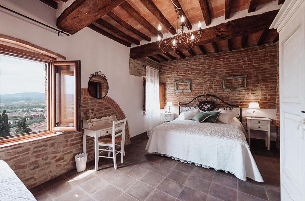 切塔尔多Antica Torre del Borgo的一间卧室设有一张床和砖墙
