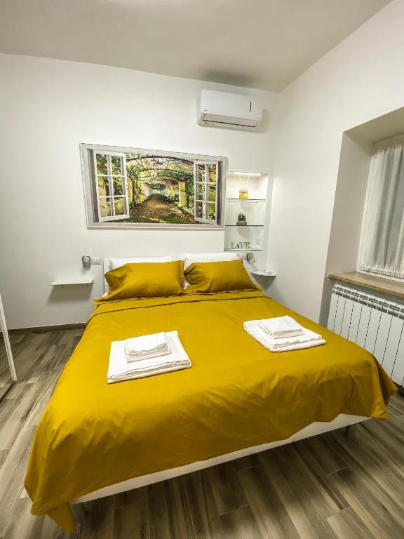 罗马Exclusive Mood Apartment的一间卧室配有黄色的床和2条毛巾