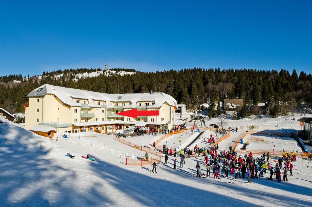 费尔德伯格Ferienwohnung Feldberg - Residenz Grafenmatt的一群人站在滑雪小屋前的雪地里