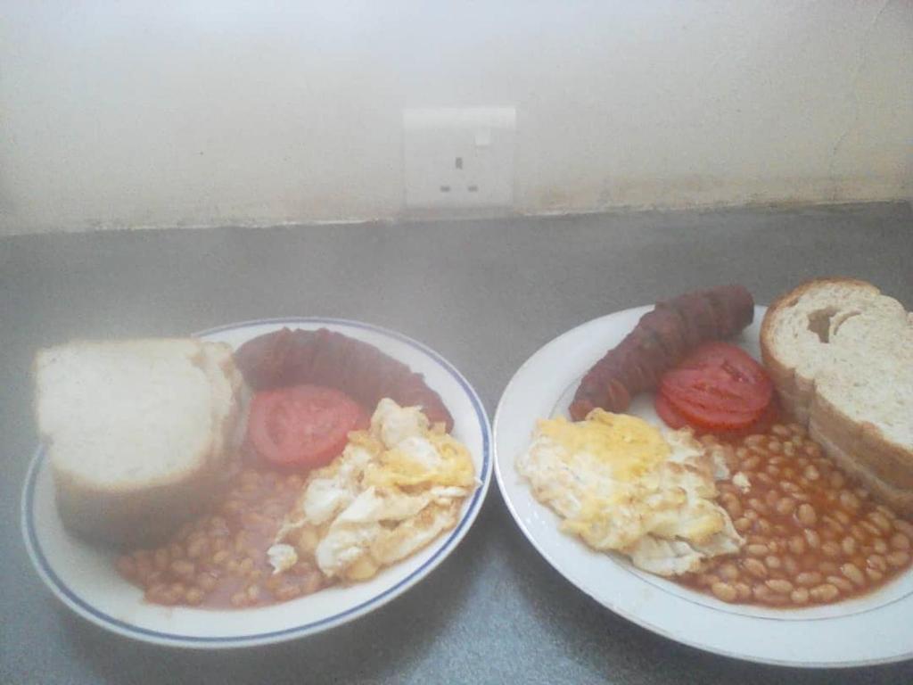 NgomaNaumba Camp and Campsite的两盘早餐食品,包括鸡蛋豆和面包