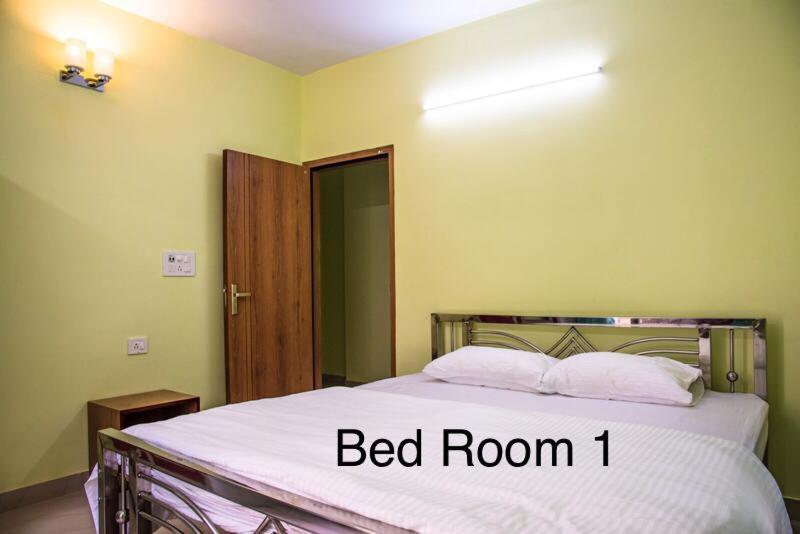 加尔各答Emerald By Olys Apartment的卧室内的一张床位,卧室内有标有床间的床位