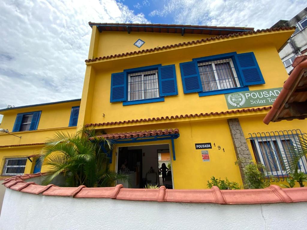 彼得罗波利斯Pousada Solar Teresa的黄色建筑,上面有蓝色百叶窗