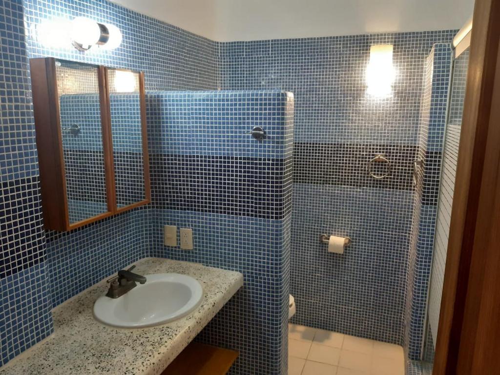 埃斯孔迪多港Casa Maya private villa on the beach的蓝色瓷砖浴室设有水槽和淋浴