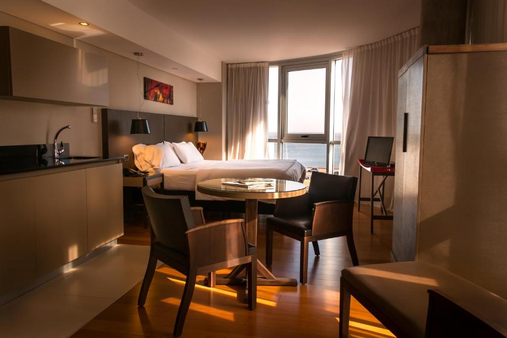 蒙得维的亚AXSUR迪赛恩酒店的配有一张床和一张桌子及椅子的房间