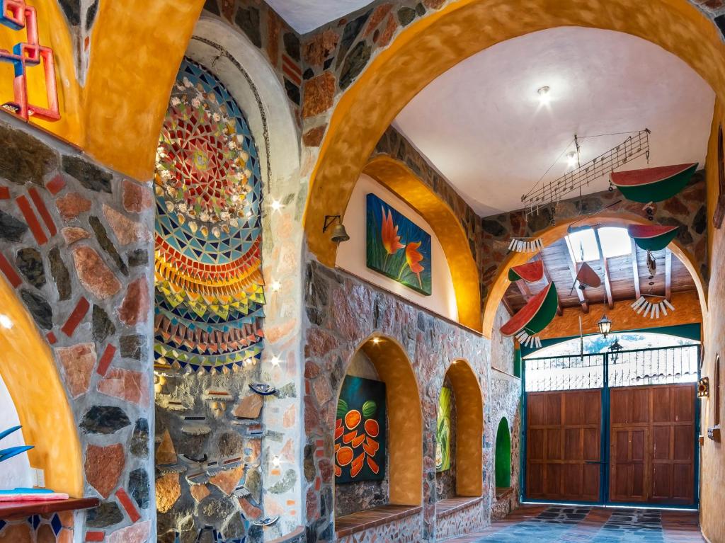 科阿特佩克Casa Miguel Arcangel的一间设有石墙和木门的房间