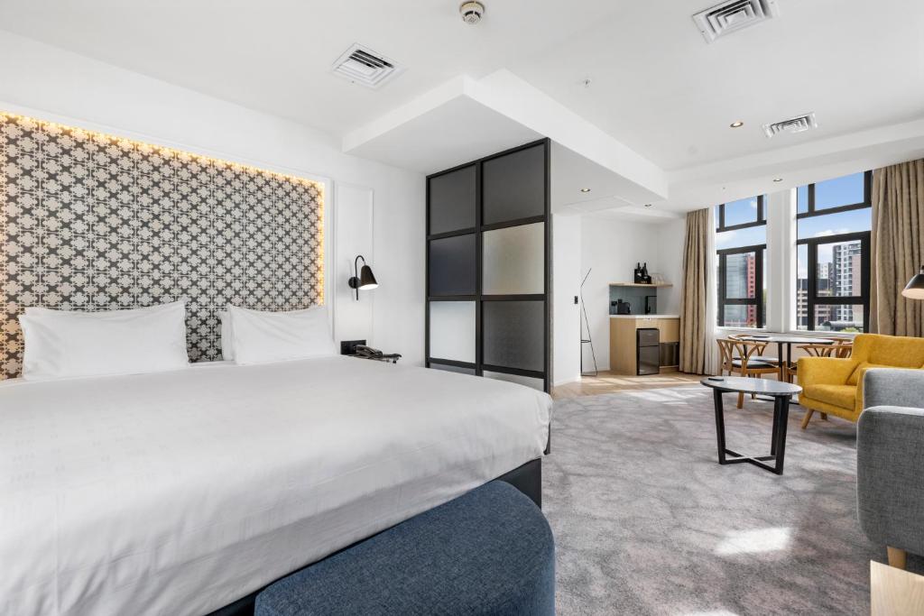 奥克兰Airedale Boutique Suites的一间卧室设有一张床和一间客厅。