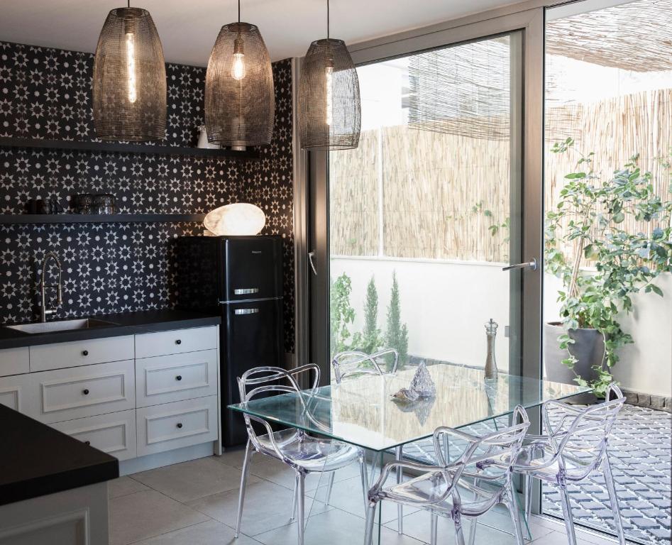 海法Etis garden seafront的厨房配有玻璃桌和椅子