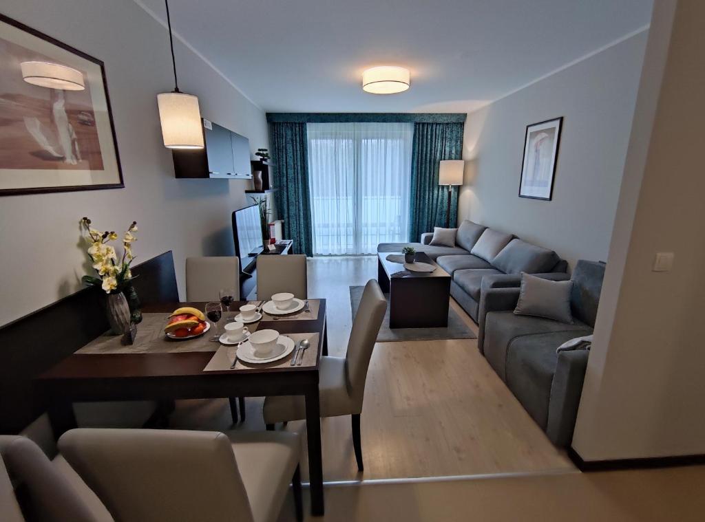 科沃布热格Apartament przy hotelu Aquarius的客厅配有桌子和沙发