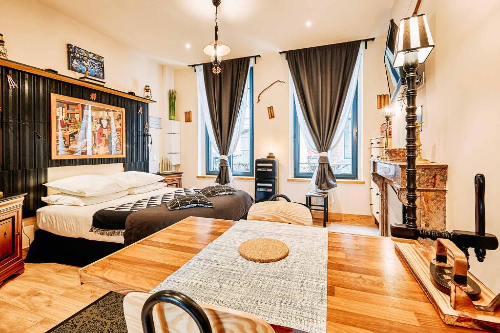 翁弗勒尔La villa des souhaits的酒店客房设有两张床和一张桌子。