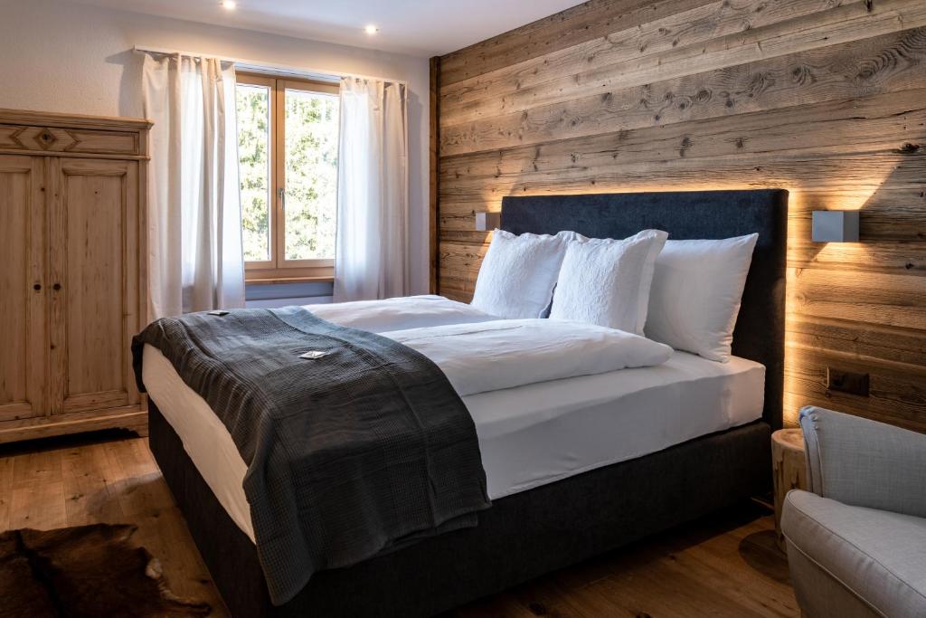 坎德施泰格Typically Swiss Hotel Ermitage的一间卧室设有一张带木墙的大床