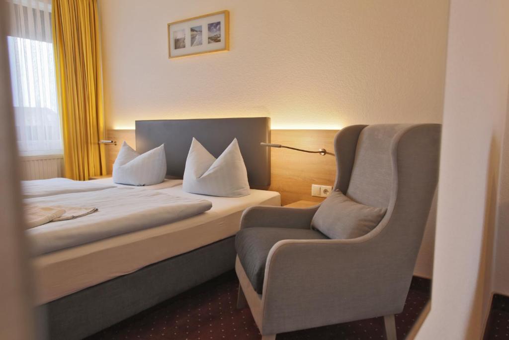 布雷格Hotel & Restaurant Am Wasser的配有一张床和一把椅子的酒店客房