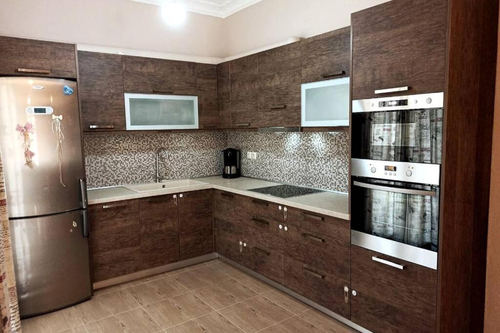 卡沃斯Myrto Guesthouse的厨房配有木制橱柜和不锈钢冰箱。