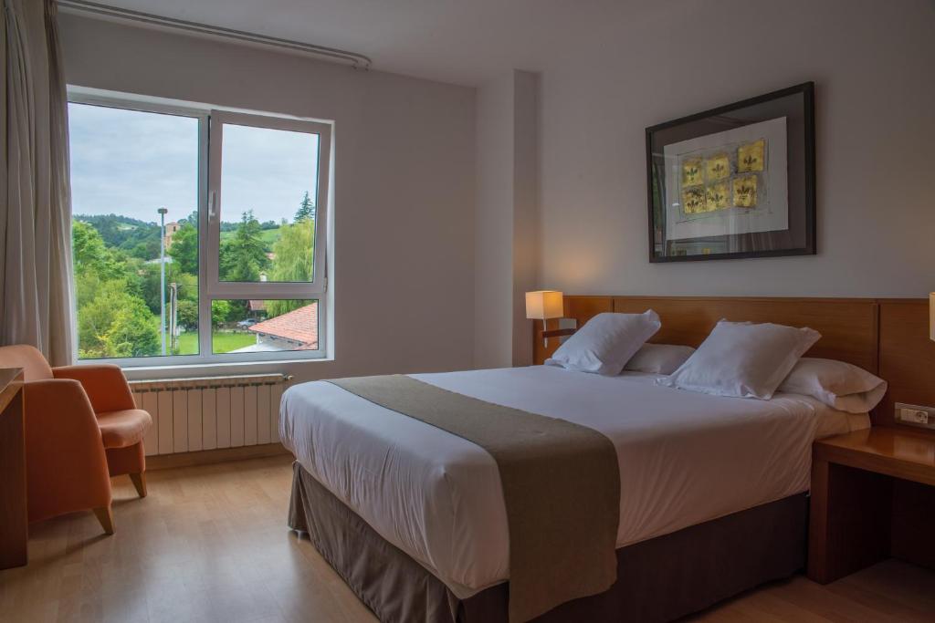 列尔加内斯米耶拉酒店的一间卧室设有一张大床和一个大窗户