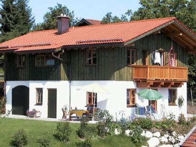 希格斯多夫Ferienwohnungen Wolfgang Geistanger的一座带橙色屋顶和阳台的房子