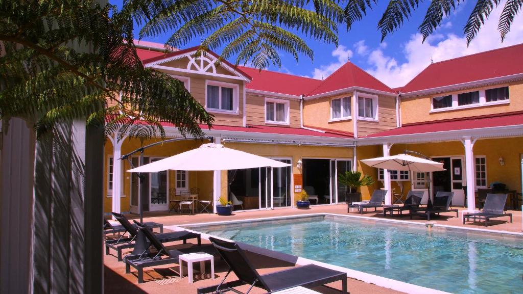 锡拉奥勒西拉奥酒店的房屋旁的游泳池配有椅子和遮阳伞