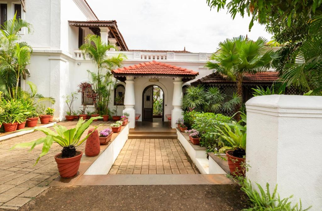 果阿旧城amã Stays & Trails Villa No 1, Goa的植物白色房子的入口