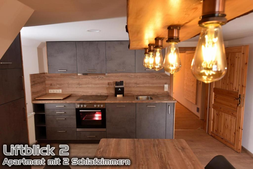 库罗阿尔滕堡Ferienwohnungen "Liftblick 2 oder 3" im Kurort Altenberg的厨房配有灰色的橱柜和木桌。