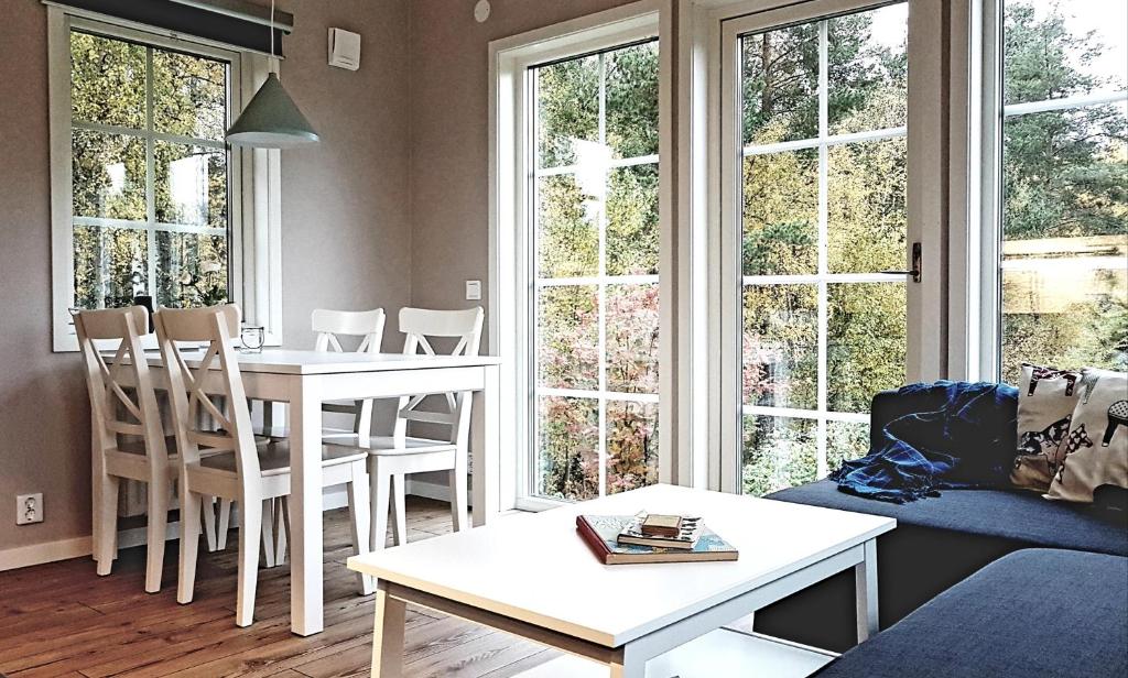 莫拉Nybyggd stuga intill skogsbrynet - New built cottage next to the cowberry forest的客厅配有桌椅和窗户。