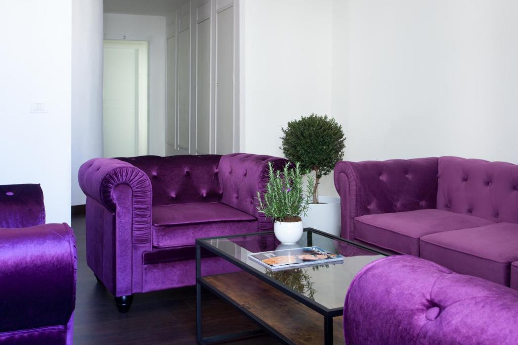 卡利亚里Myrtus Guest House Cagliari的客厅配有紫色沙发和桌子