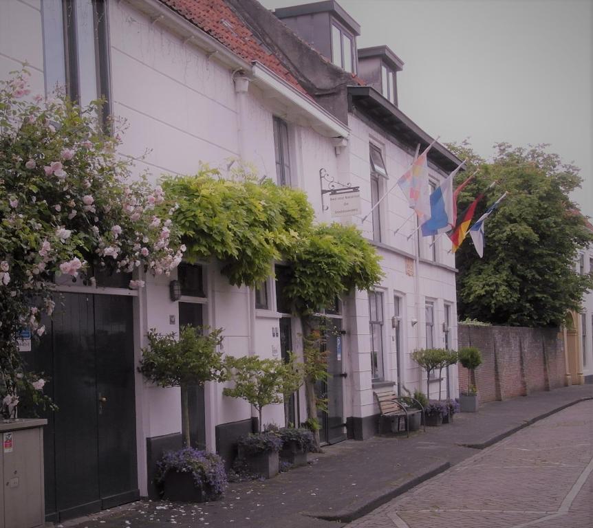 坎彭De Stadsboerderij的街道上悬挂着旗帜的白色建筑